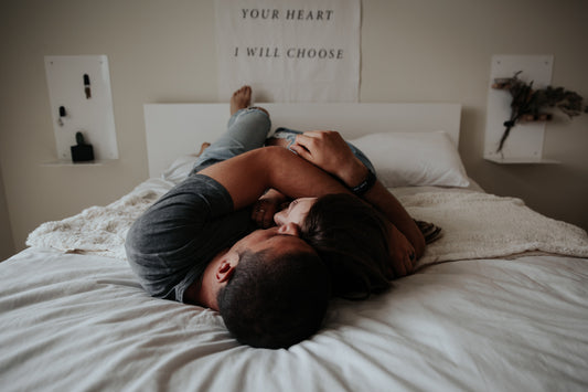 Un homme et une femme enlacés couché sur un lit